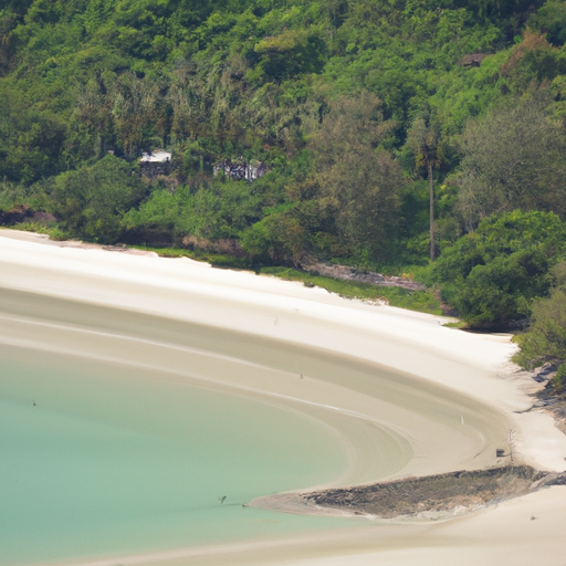 נוף ציורי של חוף תאילנדי עם מים צלולים וחול לבן, מוקף בצמחייה עבותה.